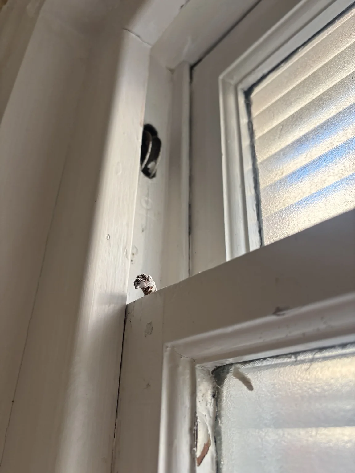 Broken sash cord visible beside a traditional timber sliding sash window