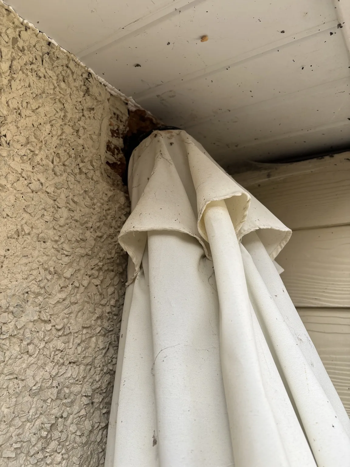 Garden parasol concealing a damaged high-level wall vent