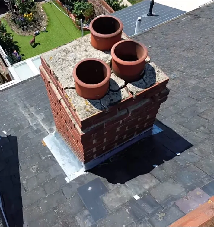 Cracked and deteriorated chimney flaunching around chimney pots