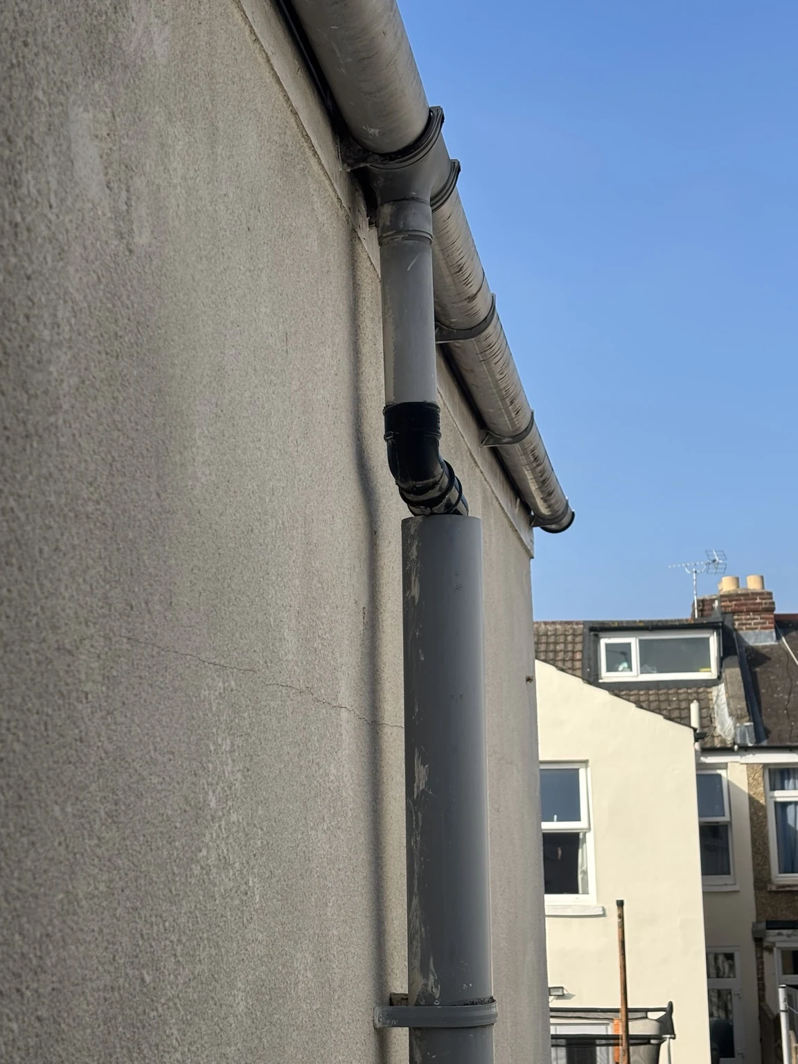 Rainwater downpipe connected into an above-ground soil pipe at a Portsmouth terrace house